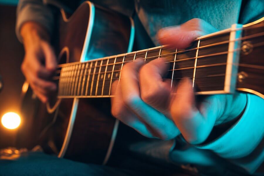 Student practising chord changes on guitar