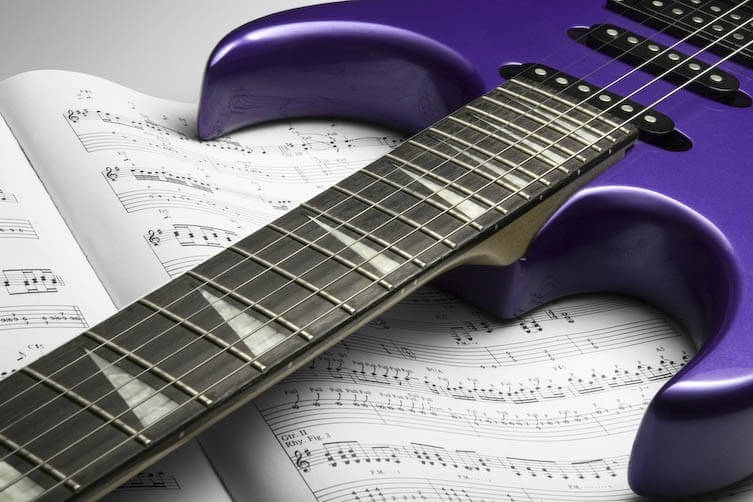 Purple guitar on sheet music